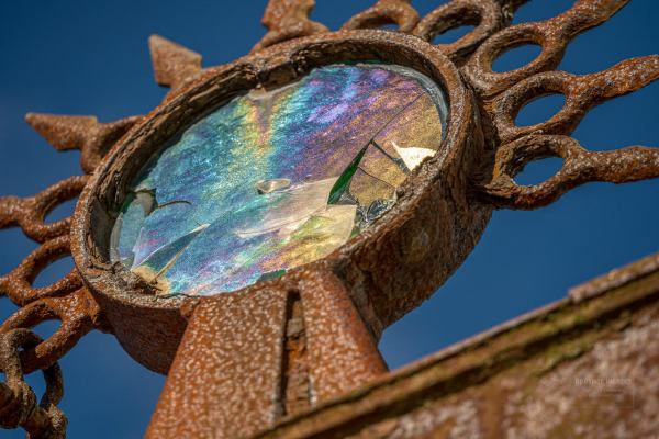 Glass artist Teresa Kowalski will replace the broken glass of the face. She chose green glass for the original work, to add a representation of the “earth” element to the metal of the statue and water it faces. Photo by: Bill Posner