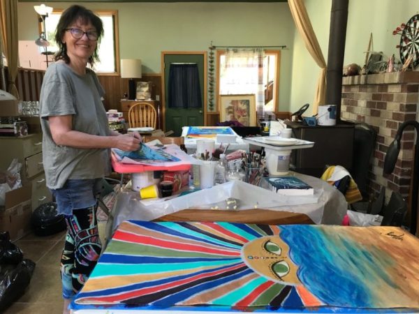 Amy Anderson, vice president of Alsea Bay Center for the Arts, prepares banners in her home studio for hanging in downtown Waldport. Photo by: Cheri Brubaker/YachatsNews.com
