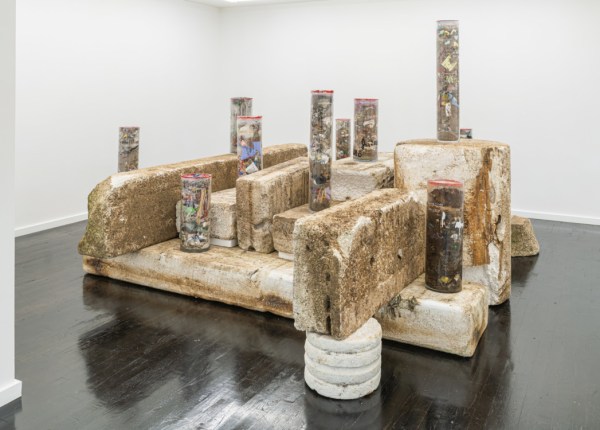 Taryn Tomasello's piece includes cylinders filled with detritis ranging from broken plates to dog kibble, resting on chunks of worn polystyrene foam.