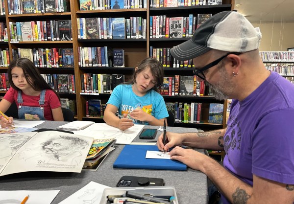 Tyler Crook (right), chair of the Willamina Public Library board, leads a Saturday drawing workshop. Crook, a professional comics artist, says, “We live in some pretty challenging times and libraries are uniquely suited to provide the things that our community needs." Photo by: David Bates
