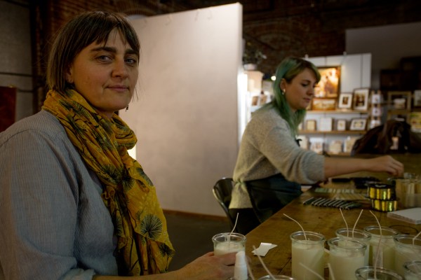 Cari Brown (left) is both director of The Workhouse and a candlemaker. Next to her at the community table in the Bend gallery is jewelry-maker /Ashley Scholtes. . Photo by: Bing Bingham