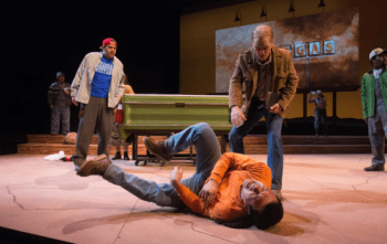 Mark Murphey (holding book) plays William Joad, who meets unexpected relative Martin Jodes, played by Tony Sancho (on ground), in Octavio Solis’ “Mother Road” at Oregon Shakespeare Festival. Photo by: Jenny Graham/Oregon Shakespeare Festival