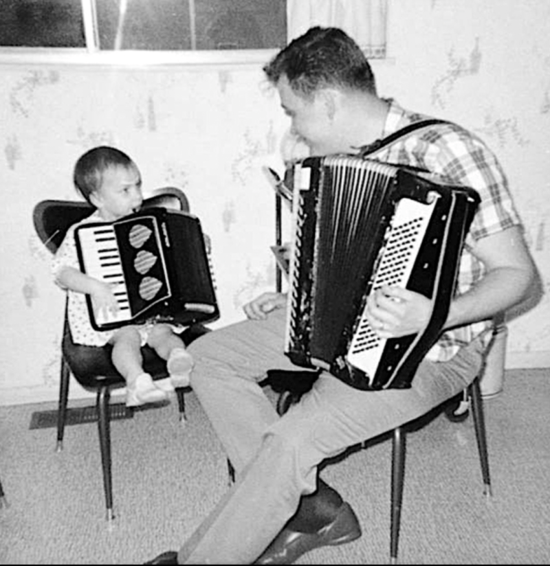 A young Thérèse Murdza with her father, both sitting down and playing accordions. Photo: Murdza family
